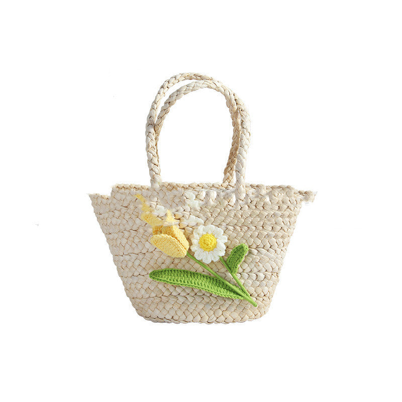 Sac en paille à motif de tulipes sur la plage en bord de mer