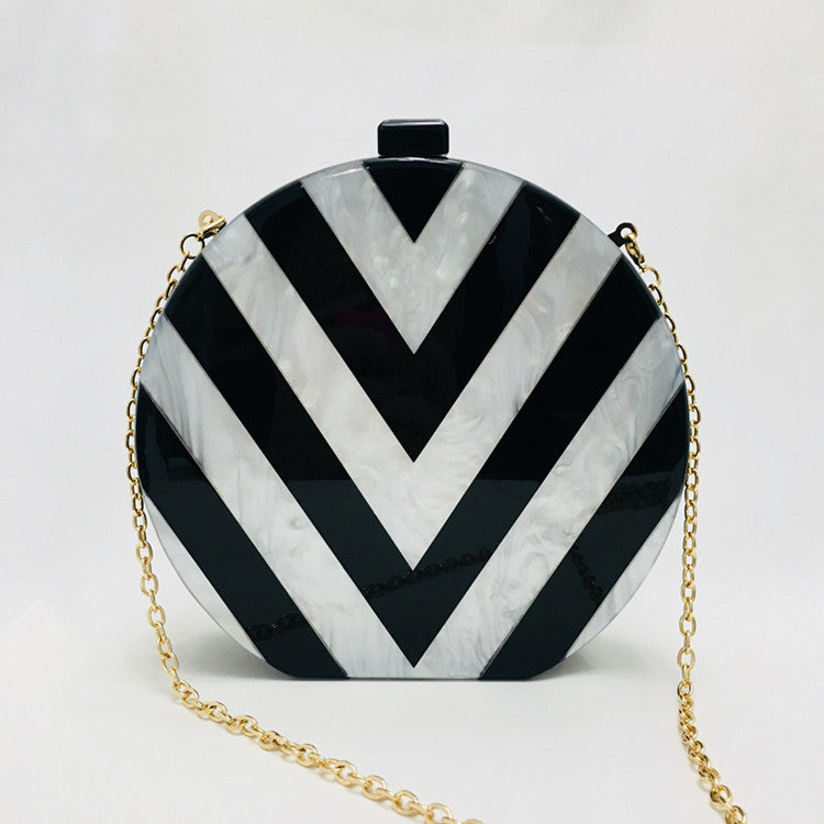 Cartera de mano acrílica con costuras geométricas en blanco y negro