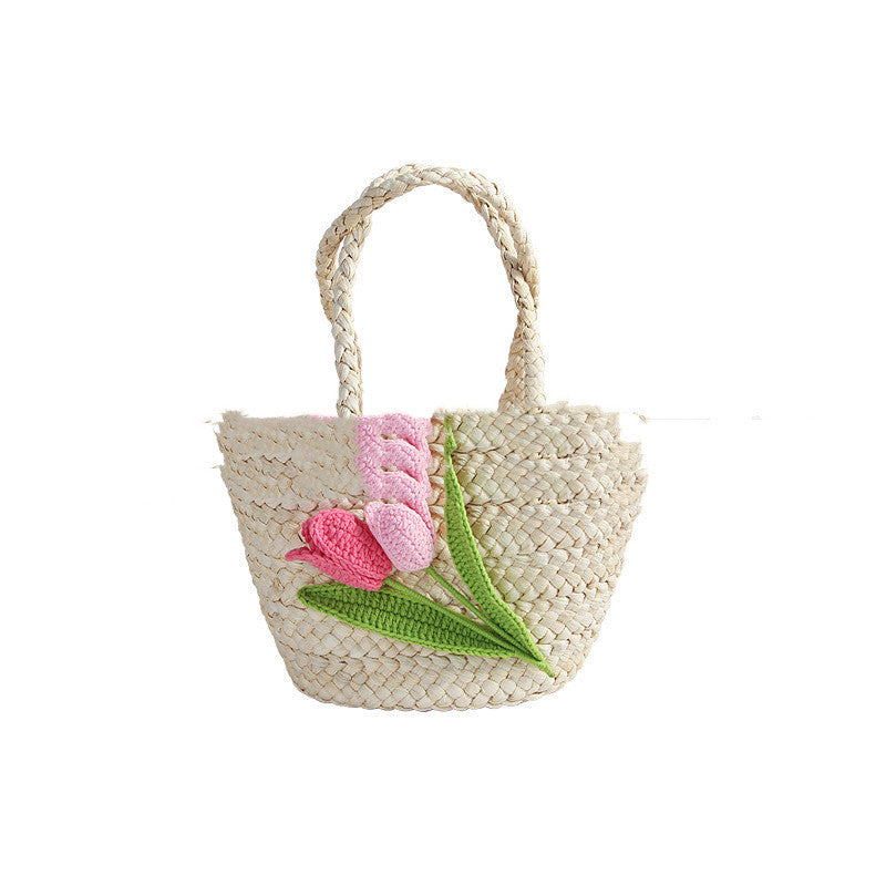 Sac en paille à motif de tulipes sur la plage en bord de mer